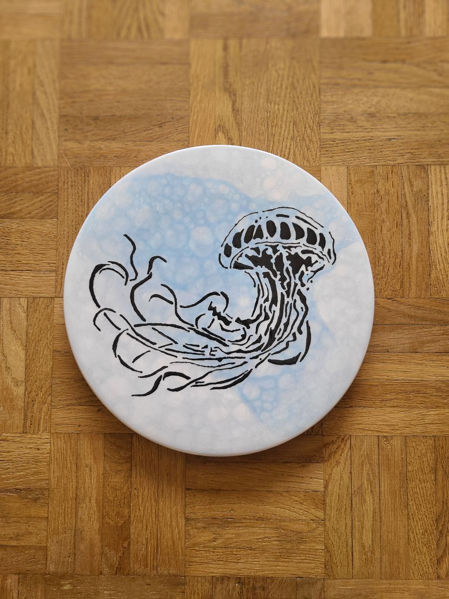 Assiette peinte d’une méduse sur fond bleu